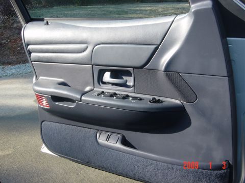 2000 Ford Crown Victoria - Interior view of a car door panel, showing the window controls and speaker grille.