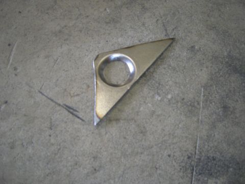 1996 Ford Bronco - A single metal bracket with a hole is shown on a textured concrete background.