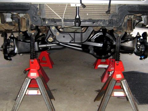 1996 Ford Bronco - Vehicle's front suspension and differential are elevated on jack stands for maintenance.