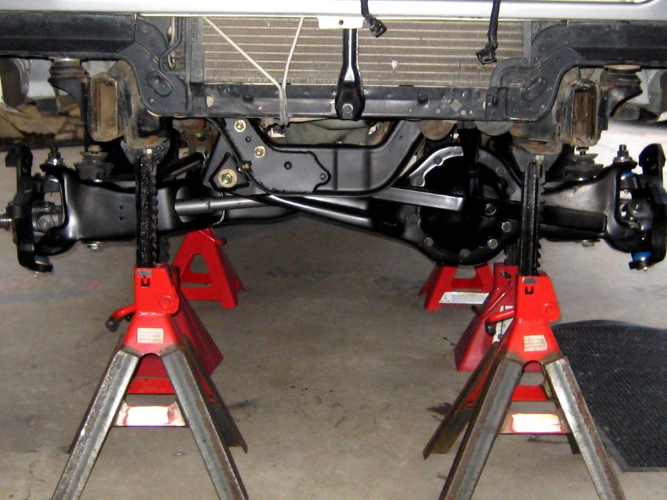 Front suspension components and differential of a vehicle supported by red jack stands