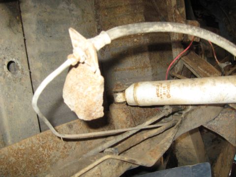 1978 Ford Bronco - Close-up of a vehicle's rear suspension showing a Rancho shock absorber and rusty metal components.