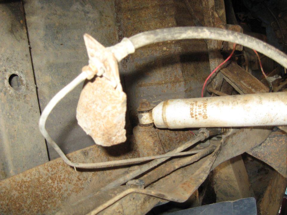 Rusty shock absorber with 'RANCHO 5118' visible, attached to vehicle suspension
