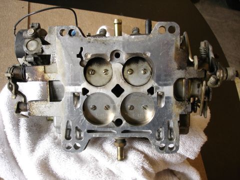 1987 Ford Crown Victoria LTD - A close-up view of a carburetor, showing its internal components and mounting points.
