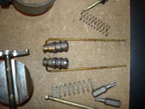 1987 Ford Crown Victoria LTD - Disassembled carburetor parts and springs are arranged on a surface, with a tool nearby.