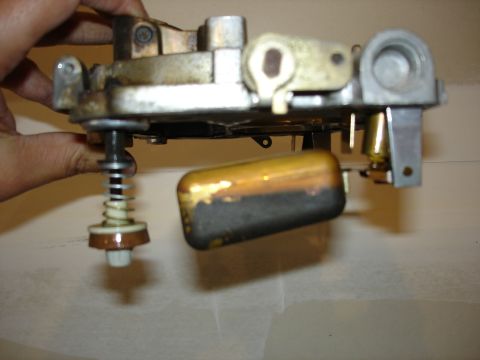 1987 Ford Crown Victoria LTD - Close-up of a carburetor float assembly, likely from an older vehicle, showing the float and needle valve mechanism.