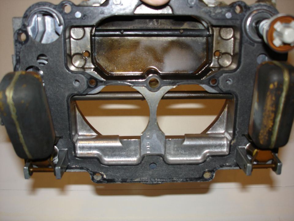 Carburetor air horn casting underside with twin bores and hanging float assemblies