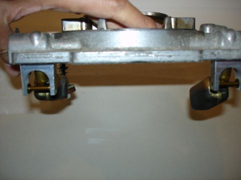1987 Ford Crown Victoria LTD - A hand holds a carburetor, likely for an engine rebuild or tune-up.