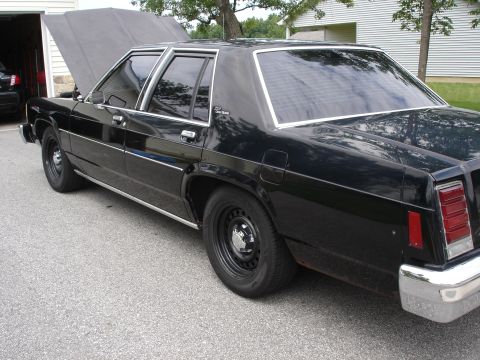 1987 Ford Crown Victoria LTD - Black 1987 Ford Crown Victoria LTD parked outside a garage with its hood raised.
