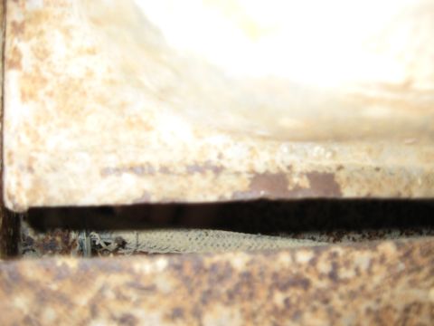 1978 Ford Bronco - Detail of corroded metal surfaces with a dark gap between them.