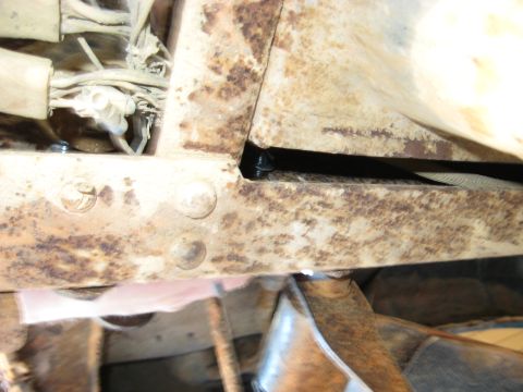 1978 Ford Bronco - Detail of heavily rusted vehicle frame components and wiring harness.