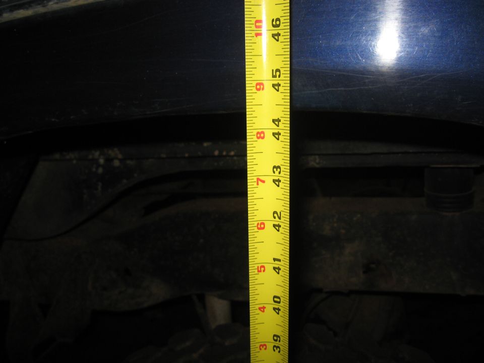 Blue vehicle body and suspension measured with tape measure