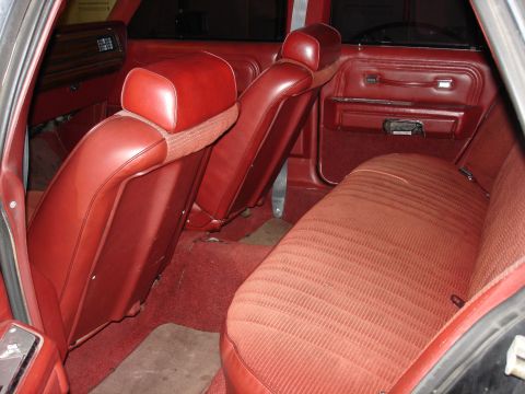 1987 Ford LTD Crown Victoria - The interior of a vintage station wagon features red leather front seats and a matching fabric rear bench seat. The door panel and dashboar…