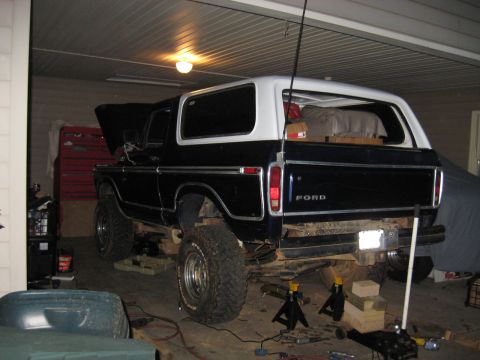 1978 Ford Bronco - Photograph of a Ford Bronco supported on jack stands in a garage during work, not a technical document.