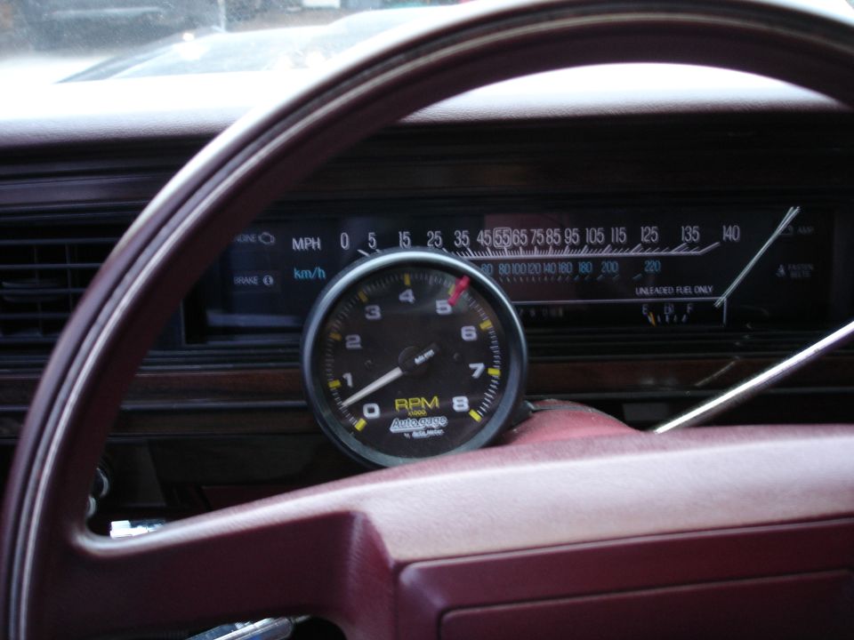 Autogage tachometer mounted on maroon dash above 140 MPH horizontal sweep speedometer