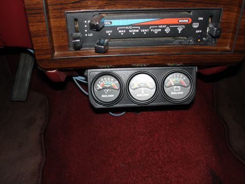 1987 Ford LTD Crown Victoria - Close-up of a black under-dash triple gauge pod holding Auto Meter Autogage oil pressure (0-100), water temperature and voltmeter (8-18V) i…