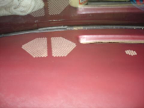 1987 Ford LTD Crown Victoria - A close-up view of the dashboard of a maroon vehicle, showing two triangular perforated speaker grilles and a smaller cluster of similar pe…