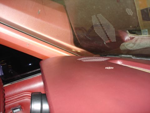 1987 Ford LTD Crown Victoria - The interior of a car shows a close-up of the dashboard and windshield area. The dashboard is covered in red leather, with visible speaker…