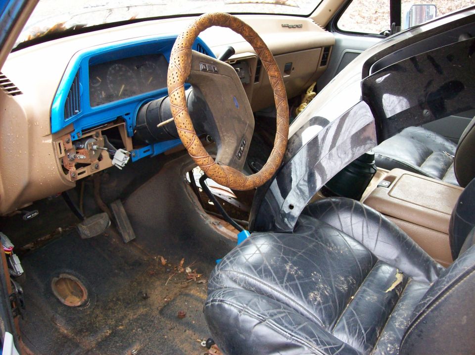 Interior of a 1987 Ford Bronco showing dashboard, steering wheel, and seats.