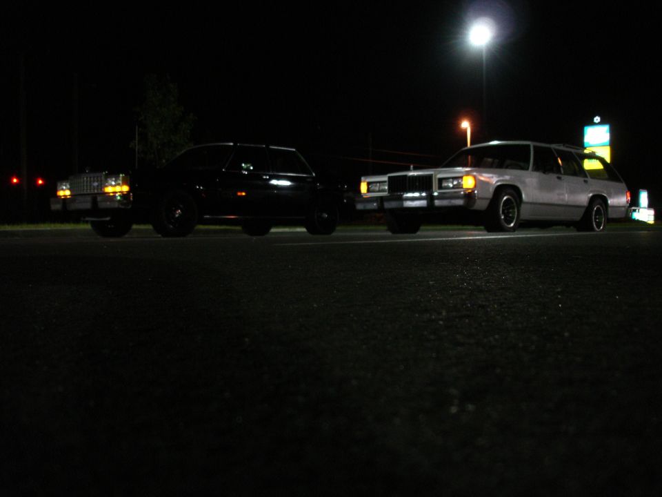 Two station wagons parked at night.