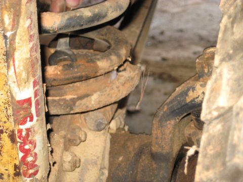 1978 Ford Bronco - Underbody photograph of a coil spring and steering components, not a technical document.