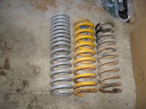 1978 Ford Bronco - Photo of three coil springs standing upright on a garage floor, not a technical document.