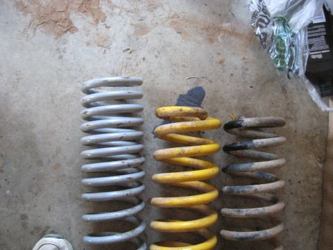 1978 Ford Bronco - Close-up photo of three coil springs on a garage floor, not a technical document.