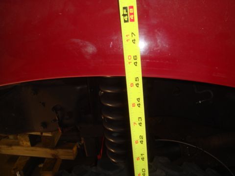 1992 Ford Bronco - A yellow measuring tape is placed vertically against the red fender of a vehicle, showing a measurement of approximately 47 inches from the…