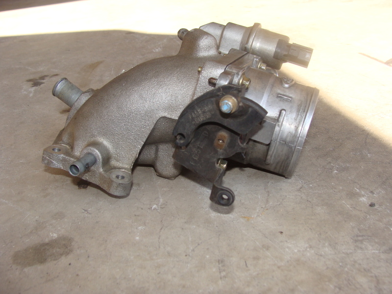 Photo of an intake manifold and throttle body assembly on a bench