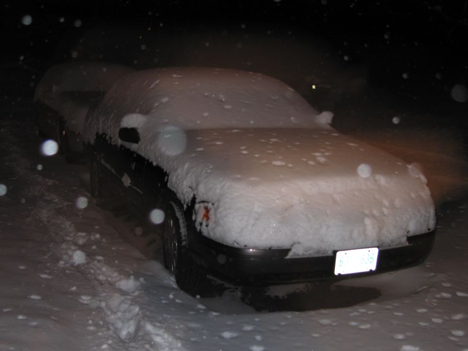 Photo of a snow-covered car at night