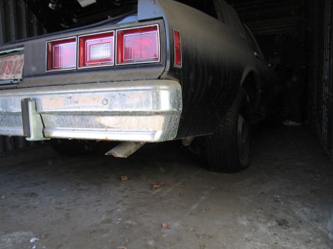 1991 Ford LTD Crown Victoria - Photograph of the rear of a car in storage, not a technical document.