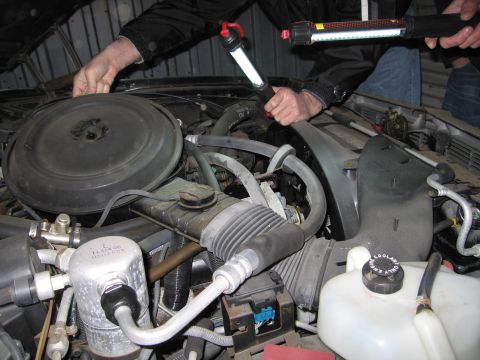 1991 Ford LTD Crown Victoria - Photograph of an engine compartment under inspection, not a technical document.