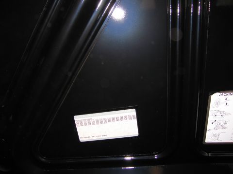 1991 Ford LTD Crown Victoria - Photograph of a trunk lid showing a barcode data label and a jacking instructions decal.