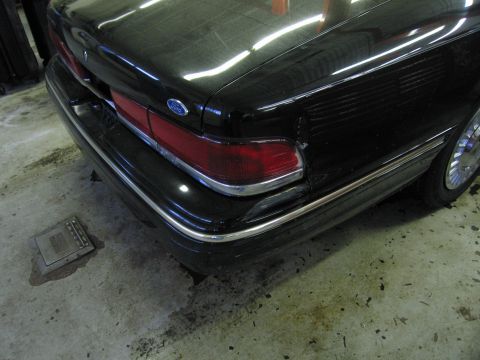 1991 Ford LTD Crown Victoria - Photograph of a black Ford sedan rear quarter panel and taillight, not a technical document.