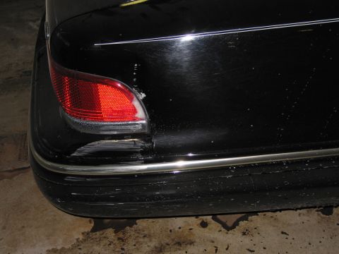 1991 Ford LTD Crown Victoria - Photograph of a black Ford sedan rear corner, taillight, and bumper, not a technical document.