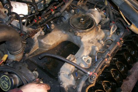 1992 Ford C-350 (Centurion Conversions) - A close-up view of the engine bay of a Ford C-350, focusing on the intake manifold and valve covers. Various hoses, wires, and engine compo…