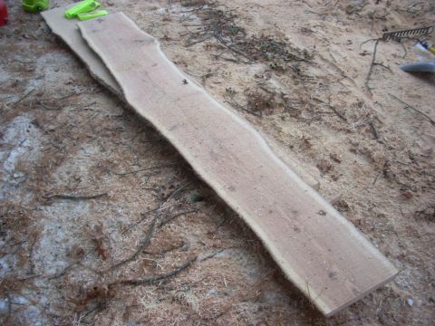 2000 Chevrolet Tahoe - Two rough-cut wood planks lie on the ground covered in sawdust and debris, with a website URL visible in the corner.