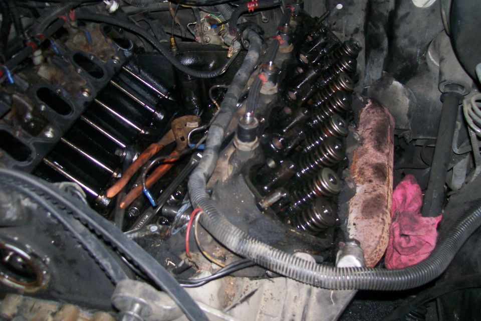 Engine with valve covers removed, showing internal components and tools