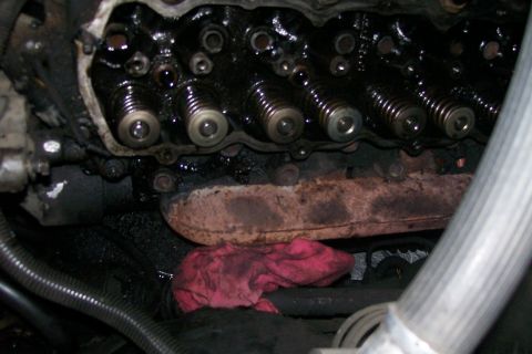 1992 Ford C-350 (Centurion Conversions) - The engine's valve train is covered in oil, with a red rag placed below the exhaust manifold.