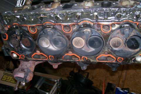 1992 Ford C-350 (Centurion Conversions) - Close-up of an engine cylinder head, showing valves and gasket. Text from a website is visible at the bottom right.