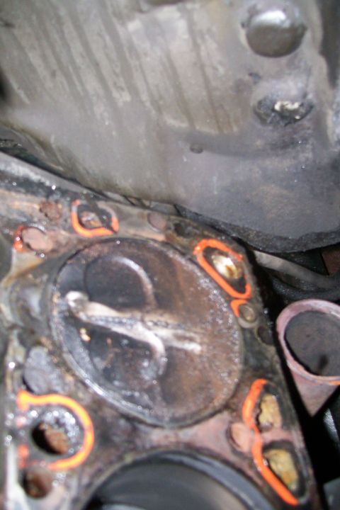 1992 Ford C-350 (Centurion Conversions) - Close-up view of a damaged engine cylinder head, showing the gasket and signs of wear and tear.