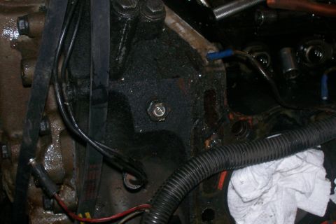 1992 Ford C-350 (Centurion Conversions) - Close-up of an engine block showing oil residue and various engine components.