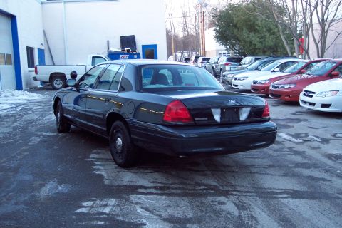 2001 Ford Crown Victoria - Rear view of a dark 2001 Ford Crown Victoria parked outdoors in a lot.