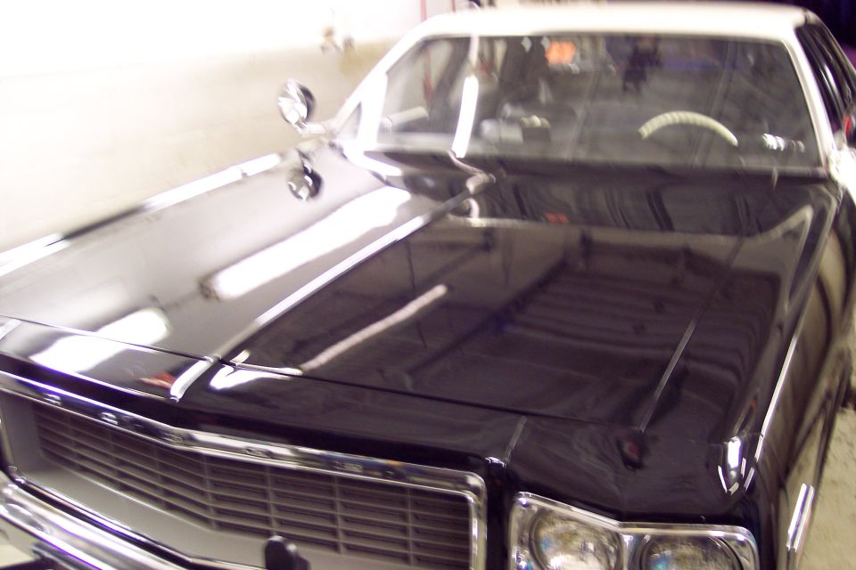 Front view of a black and white police car, showing the hood and grille.