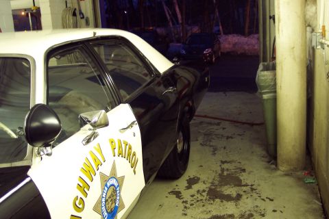 2001 Ford Crown Victoria - A police car is parked on the side of a building at night.