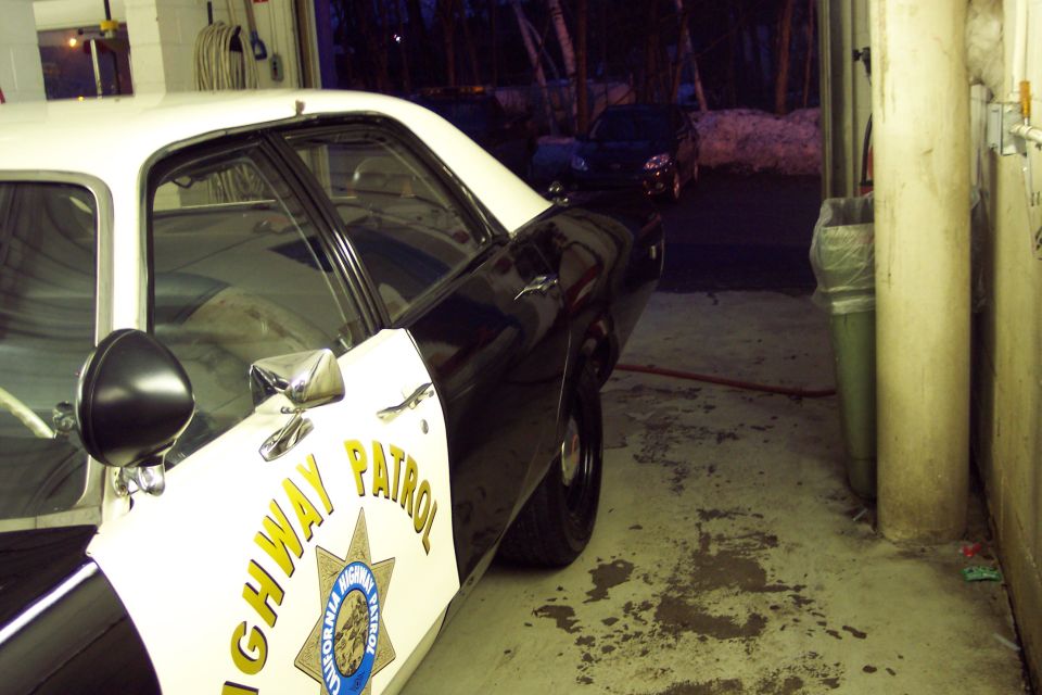 Side view of a police car parked next to a building