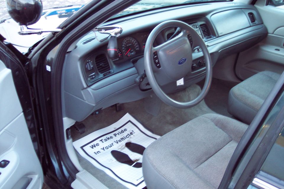 Interior of a 2001 Ford Crown Victoria, showing dashboard, steering wheel, and driver's seat.
