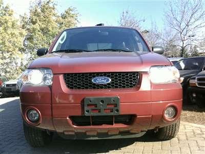 2006 Ford Escape - The front grille and Ford logo are visible on this red SUV.
