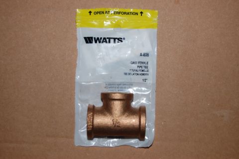 1989 Ford Bronco - A brass 1/2 inch pipe tee fitting is shown inside its original packaging. The packaging is white with a yellow header that reads "OPEN AT P…