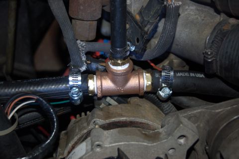1989 Ford Bronco - A close-up view shows a copper T-fitting installed in a vehicle's engine bay, connecting three rubber hoses secured with hose clamps. One h…