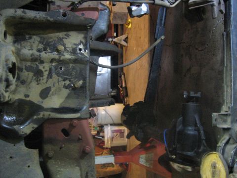 1989 Ford Bronco - The image shows a close-up view of vehicle frame and suspension components, with some parts on jack stands.